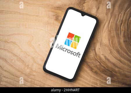 Microsoft logo on smartphone screen. Wooden background. Top angle shot Stock Photo