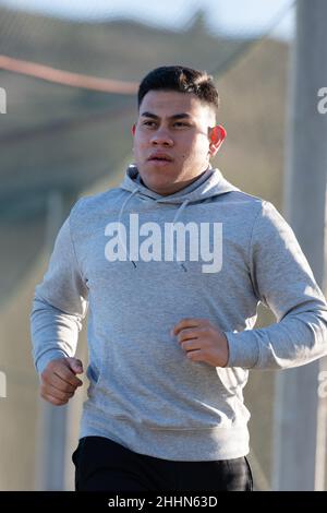 Young latin man running while thinking on his goals. Losing weight concept. Stock Photo