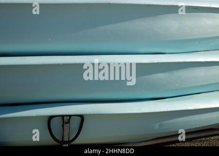 Three stacked light blue canoes shot close up in landscape format Stock Photo