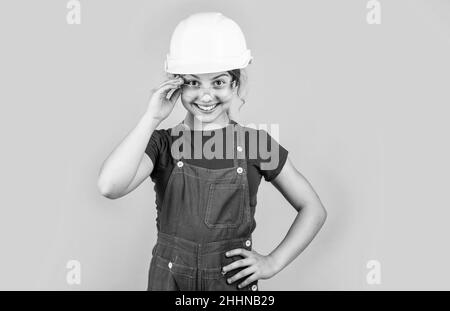 foreman teen child. kid work in helmet. little girl in a helmet. girl making repairs. teen dressed in hard hat. concept of childhood development. girl Stock Photo