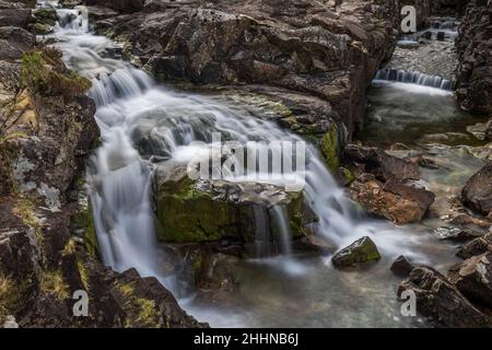 The River Coe rises at the north-eastern base of Buachaille Etive Beag in Scotland and flows west along Glen Coe.  After dramatic waterfalls at the Pa Stock Photo