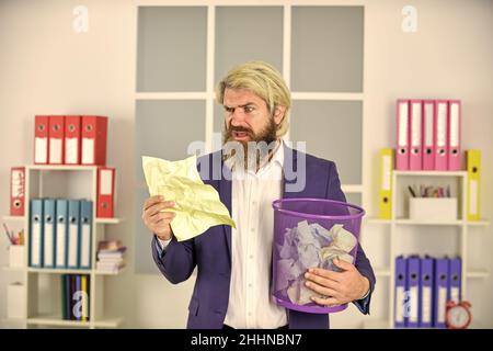 Vile work. Recover document. Office worker digging in garbage. Recover files after deletion. Businessman hold trash can. Man look for lost document Stock Photo