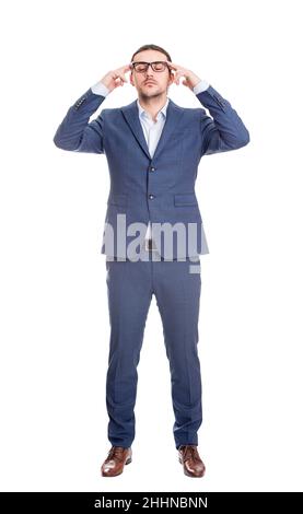 Full length portrait of young businessman keeps hands to temples focusing his thoughts, isolated on white background. Reflective business person plann Stock Photo