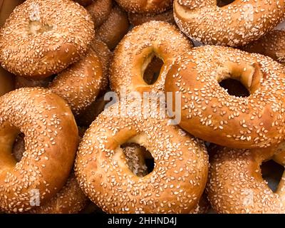Close-up of a pile of freshly baked bagels sprinkled with sesame seeds. Stock Photo