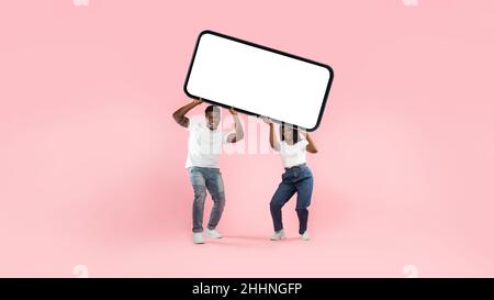 Black couple holding heavy white empty smartphone screen Stock Photo