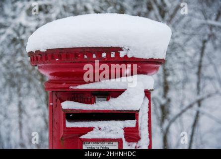 Close up of red pillar box covered in snow. Stock Photo