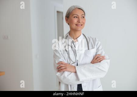 Mature woman physician standing in hall of the hospital Stock Photo