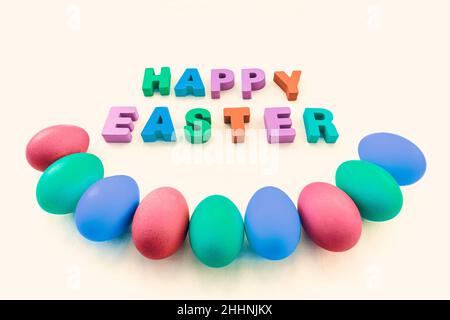 Necklace from hand-painted Easter eggs on a beautiful tablecloth. Happy Easter inscription on the table Stock Photo