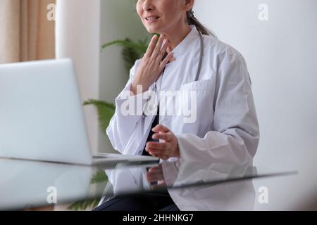 Close-up photo of medical worker putting her hand to throat Stock Photo