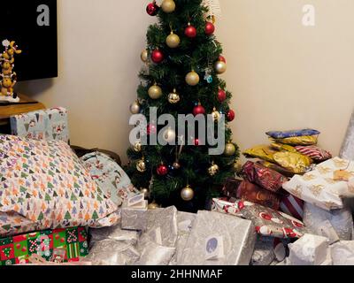 Disorganised pile of presents around a Christmas tree, UK Stock Photo