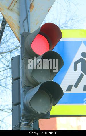 Traffic light for pedestrians with a red light on a pillar in the city. Scenic travel background. Highway transportation concept. Stock Photo
