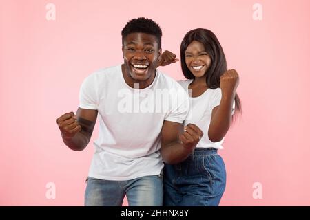 Portrait of happy young black couple shaking clenched fists Stock Photo