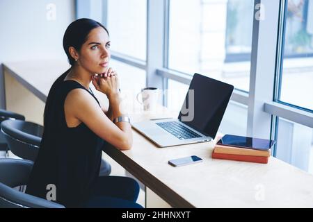 Calm female entrepreneur sitting at workplace Stock Photo