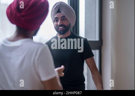 Two men in turbans talking and looking involved Stock Photo