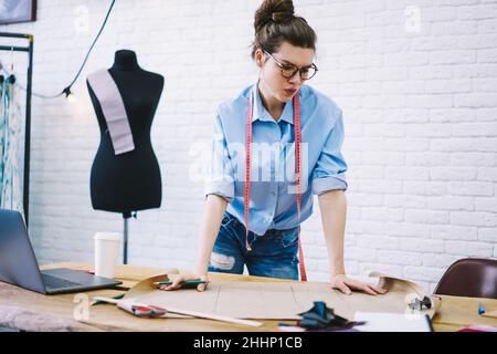 Focused clothes designer making drawings in fashion studio Stock Photo