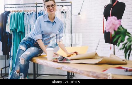 Happy woman working in modern atelier Stock Photo