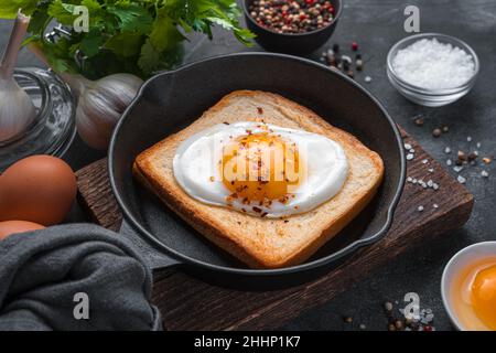 Breakfast with fried eggs in a frying pan on a dark background. Stock Photo