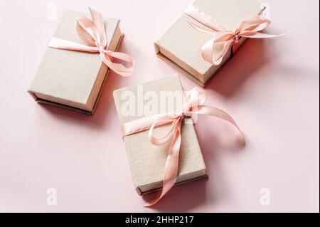 Christmas presents. Set of gift boxes with pastel ribbons on pink background, top view, flat lay. Stock Photo