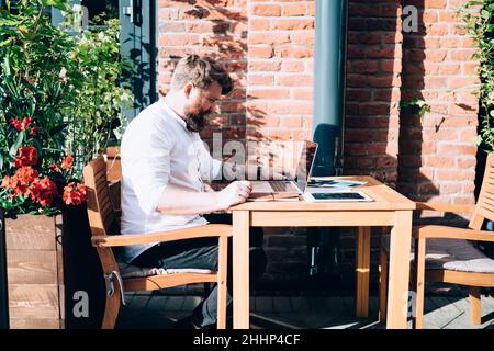 Serious man using laptop while working outside Stock Photo