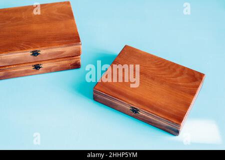 Wooden gift boxes on blue background. Handmade boxes for keeping pictures, top view, flat lay. Stock Photo