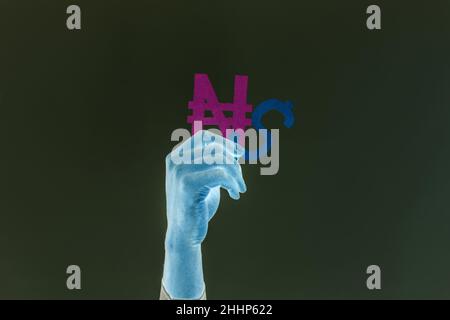 Cold hand holding naira and dollar signs in the dark background Stock Photo