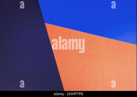 Abstract colored paper backgrounds with copy space. Navy, orange and blue colors.  Diagonal geometric composition in dark tones. Top view, flat lay. Stock Photo