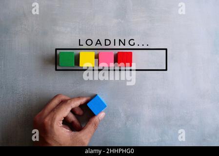 Top view image of loading bar with colorful wooden blocks on concrete floor. Stock Photo