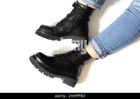 Black female fall winter boots isolated on white background with shadows with round toe, block heel and embossed hard sole worn on someone feet. Copy Stock Photo