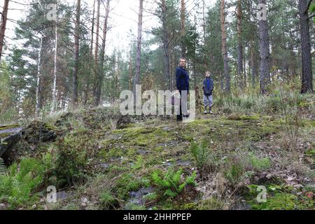 Mother and son pick mushrooms in forest, Karelia Stock Photo