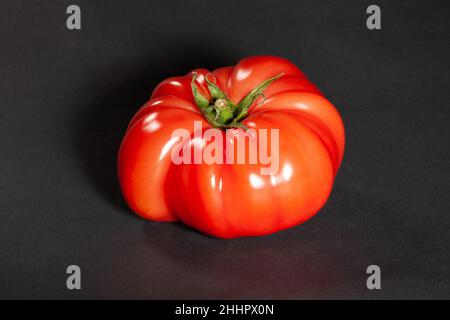 pink tomato on black background Stock Photo