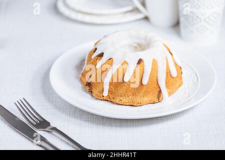 Easter cake with colorful eggs in a chocolate nest on white background. Happy Easter concept. Dessert also known as  Kuglof Stock Photo