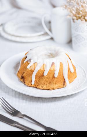 Easter cake with colorful eggs in a chocolate nest on white background. Happy Easter concept. Dessert also known as  Kuglof Stock Photo