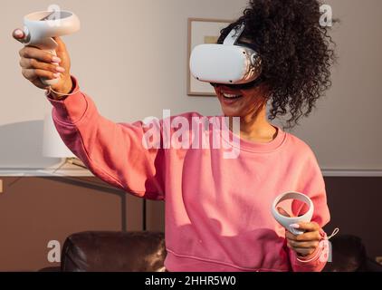 Smiling woman with VR headset having fun in the living room Stock Photo