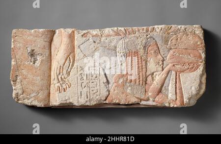 Relief Depicting the Nurse Tia ca. 1353–1336 B.C. New Kingdom, Amarna Period The block evokes a scene of the king before a crowd. On the right, an elegant hand dangles alongside the thigh of a royal male, surely Akhenaten. Behind him is a woman labeled 'the nurse of the king’s daughter Ankhesenpaaten, Tia.' Tia faces to the right and holds small loaves to cajole the restive young princess, whose garment is just visible on the far right where she stands for the court ceremony.. Relief Depicting the Nurse Tia. ca. 1353–1336 B.C.. Limestone, paint. New Kingdom, Amarna Period. From Egypt; Probably Stock Photo