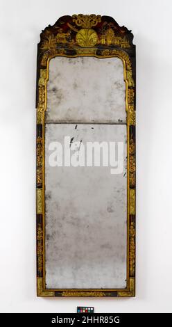 Looking glass 1730–60 American Japanning, the use of paint and gilded gesso to imitate the glossy finish on Asian lacquerwork, was a popular method of furniture decoration in colonial Boston. This looking glass, part of a group (40.37.1, .2, .4) of japanned furniture that descended in the Pickman family of Salem, Massachusetts, is an extraordinary survival. The painted decoration on the high chest, dressing table, and looking glass is all by the same hand.. Looking glass. American. 1730–60. White pine. Made in Boston, Massachusetts, United States Stock Photo