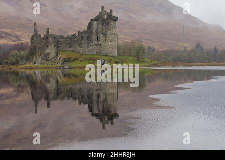 Kilchurn castle on Loch Awe is seen partially frozen as low temperatures in the Met weather amber warning for snow and ice.  Credit: Euan Cherry Stock Photo