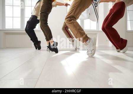 Group of hip hop dancers who together perform stand on toes during rehearsal in dance studio. Stock Photo