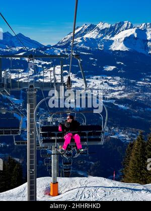 Vertical view of woman on chair lift in french alps, Europe Stock Photo