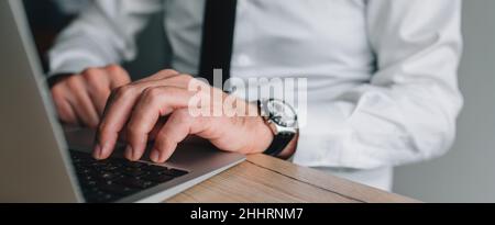 Data entry operator working on laptop computer in business office, panoramic image with selective focus Stock Photo