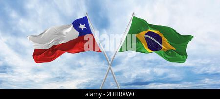 crossed national flags of Brazil and Chile flag waving in the wind at ...