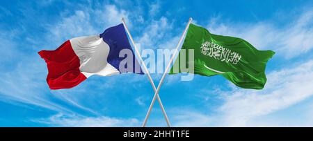 two crossed flags France and Saudi Arabia waving in wind at cloudy sky ...