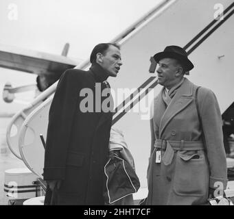 Singer Frank Sinatra seen here with Sunday People journalisrt Arthur Helliwell about to board a TWA flight to New York at London Airport . Circa December 1952 Stock Photo