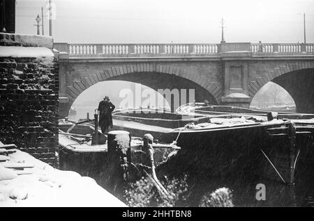 A lighterman secures his barges below Kingston Bridge on the River Thames. Circa January 1939 Stock Photo