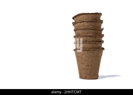 several empty peat pots for seedlings inserted one into the other isolated on a white background. Stock Photo