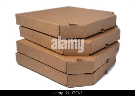Stack flat brown cardboard pizza boxes isolated on a white background, light snack. Stock Photo
