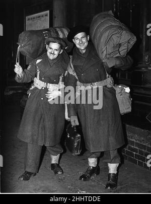 Two heavily laden soldiers of the British Army, Sergeants Lester (left) and Jarvis, arrive home in happy mood from the Middle East during the Second World War. 7th January 1944. Stock Photo