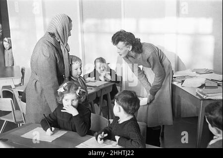 A mother drops off her son at his new school, South Mead School, Southfield, Wimbledon. Seen here meeting his new teacher for the first time. 14th January 1954 Stock Photo