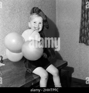 All dressed up in his Royal Stewart Tam O'Shanter hat and tartan scarf this happy 3 year old, Steve Lyons, looks forward to the new year with the time honoured 'A Guid New Year tae Ane an Aa'. 30th December 1954. Stock Photo