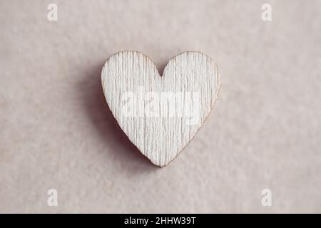 Wooden heart on paper background, love concept, minimalist Valentines day design Stock Photo