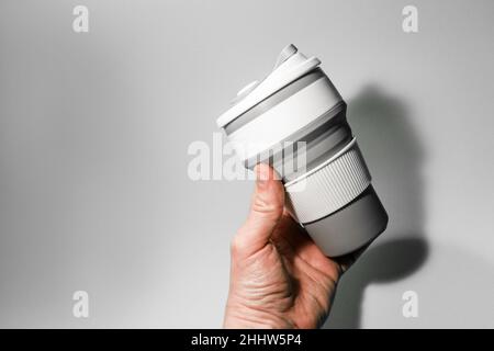 Reusable silicone cup for coffee in hand on a white background.  Stock Photo